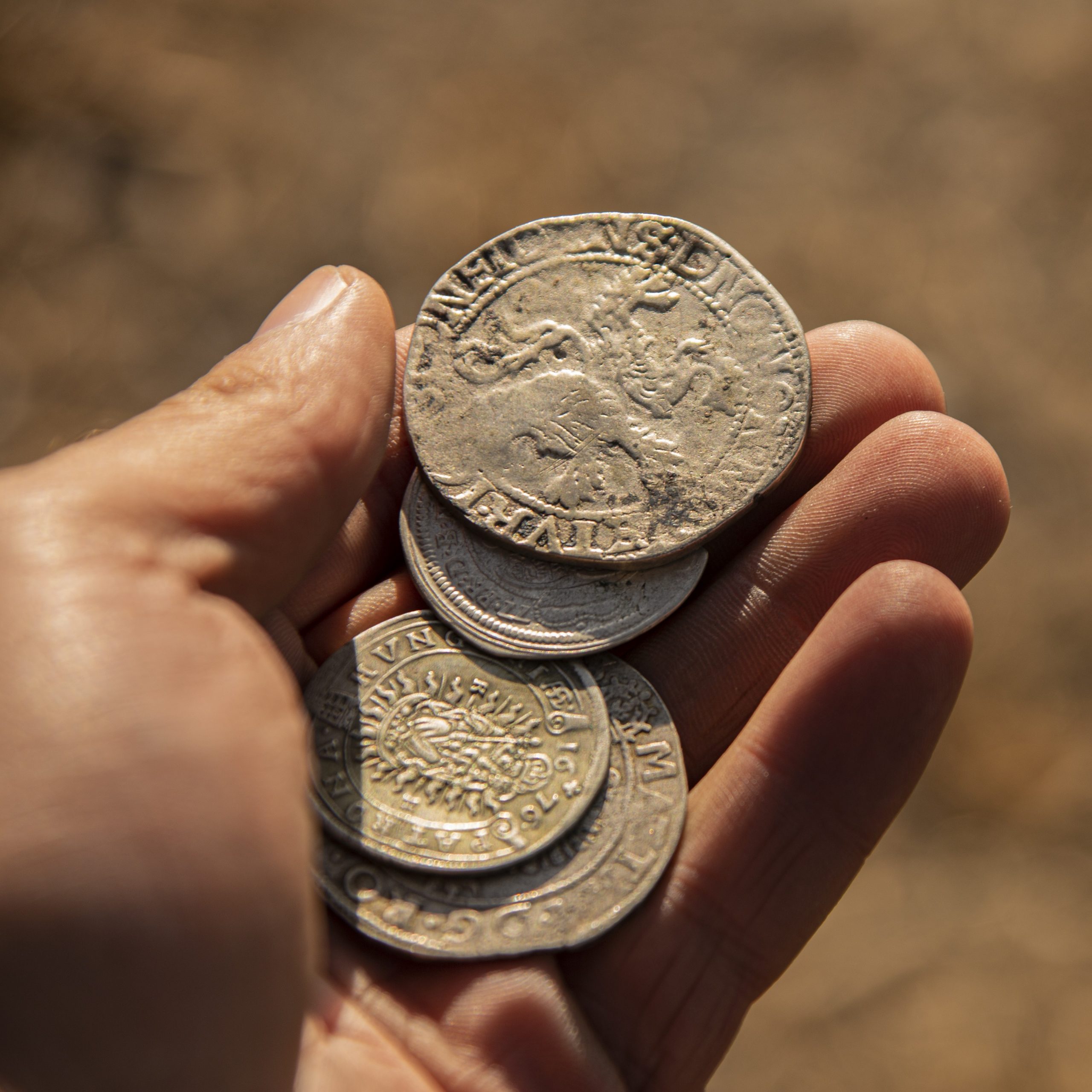 ancient silver coins in hand